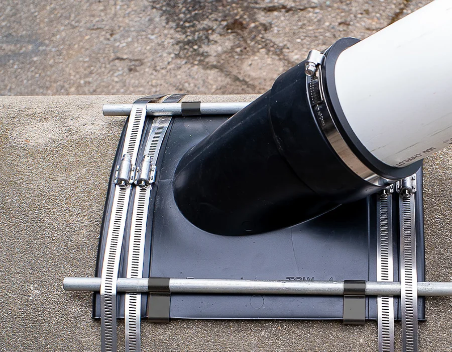 Fernco Flexible Tap Saddle wye clamped to a sewer main with a PVC branch