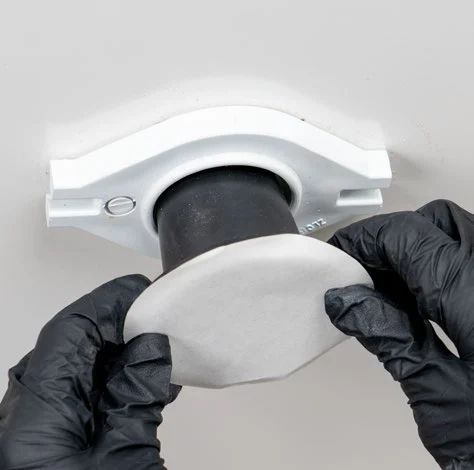 Inserting the Fernco urinal seal into the wall adapter and peeling the release paper